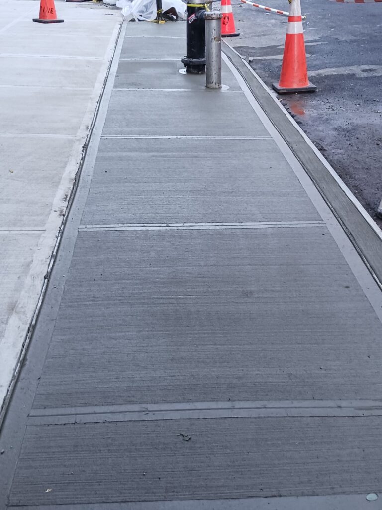 a concrete sidewalk fixed in 2025 in a residential area